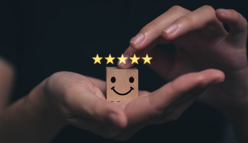 A person holding a wooden star with a smiley face on it.