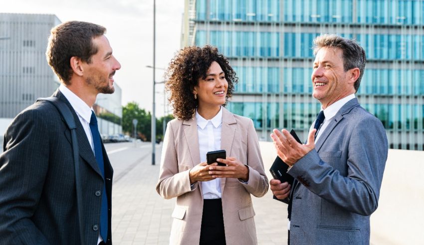 Three business people talking in front of a building.