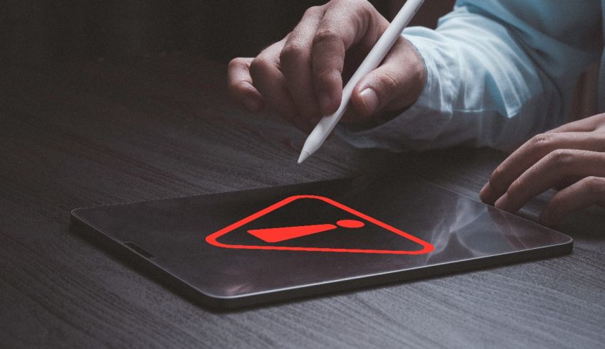 A person holding a tablet with a red sign on it.