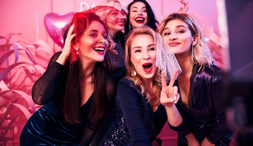 A group of women posing for a photo in a pink room.