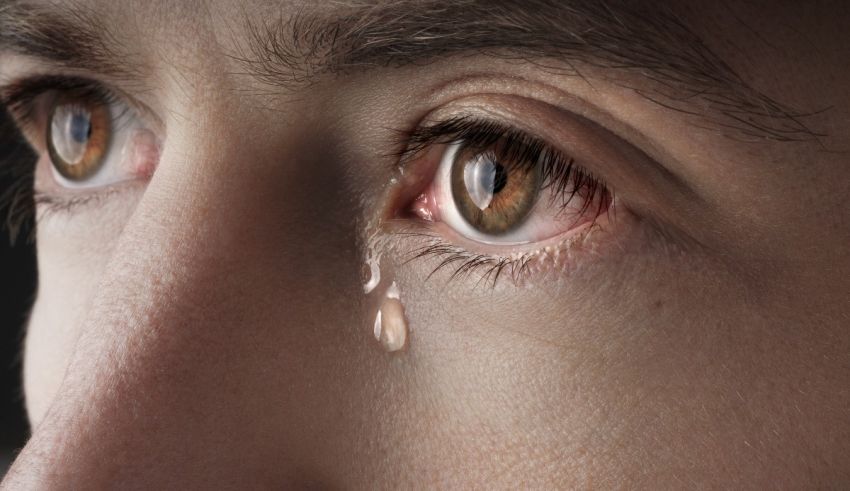 A close up of a woman's eye with tears on it.