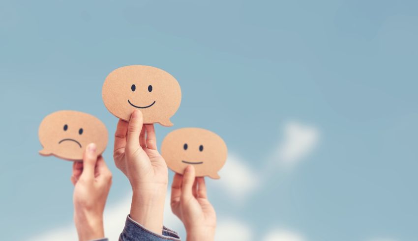 A group of people holding up paper smiley faces.