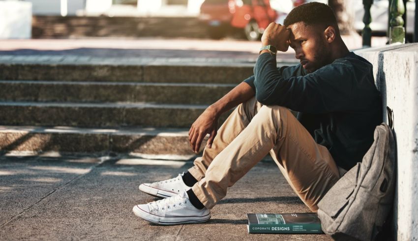 A man sitting on the steps with a backpack on his head.