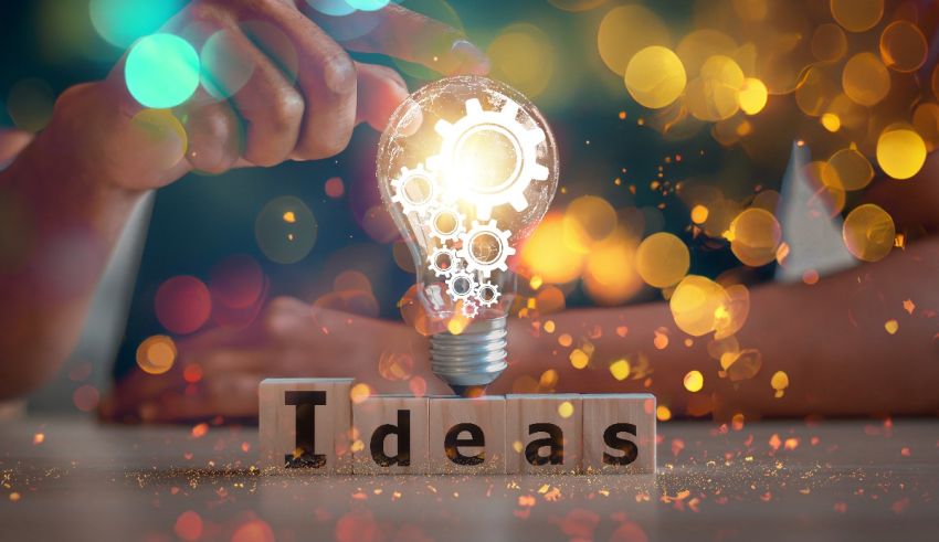 A person holding a wooden block with the word ideas on it.