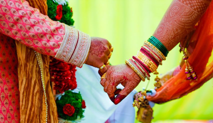 A bride and groom holding hands in an indian wedding.