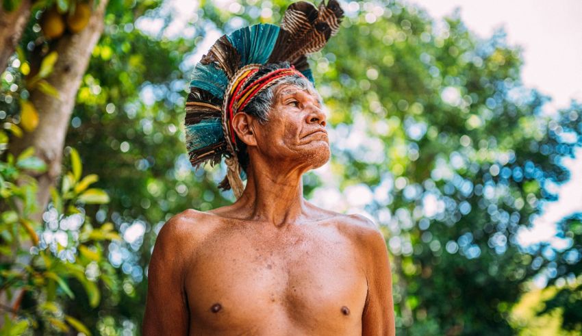 An indigenous man wearing a feathered headdress.