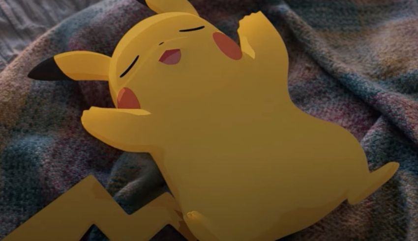 A pikachu is laying on a blanket.