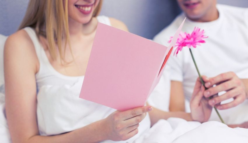 A man and woman reading a valentine's day card.