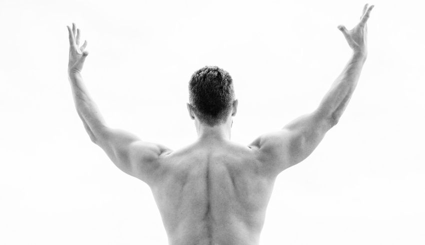 A black and white photo of a man with his arms raised.