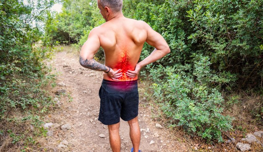 A man with back pain on a trail.