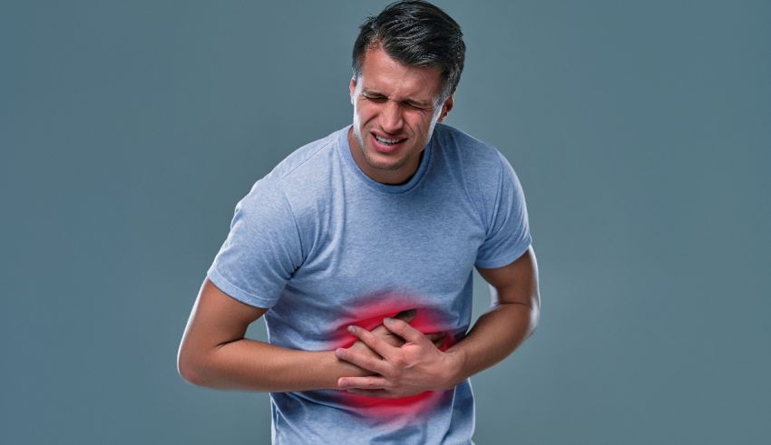 A man with a stomachache holding his stomach.