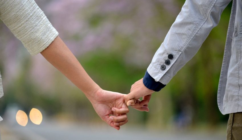 A man and woman holding hands on a street.