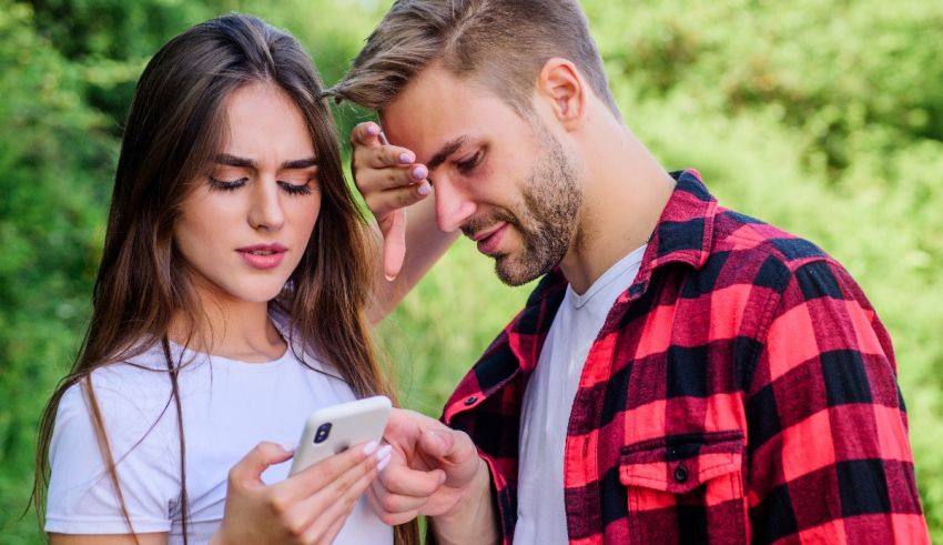 A man and woman looking at a cell phone.