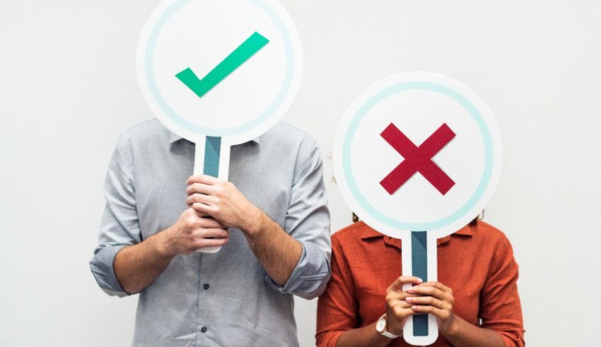 A man and woman holding up a magnifying glass with a check mark on it.