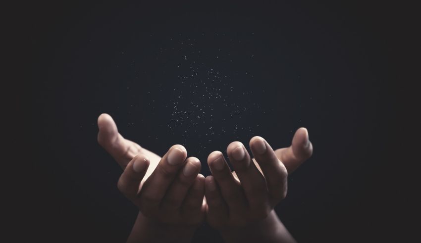 A woman's hands reaching out to the stars on a black background.
