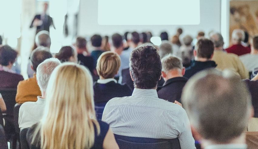 A group of people sitting in a conference room.