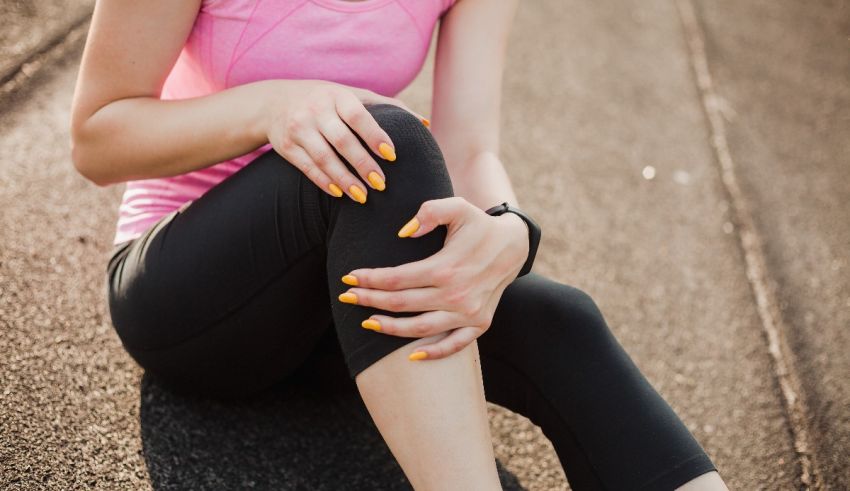 A woman with a knee injury sitting on the road.