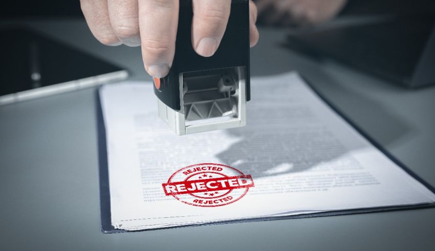 A person stamping a document with the word rejected.