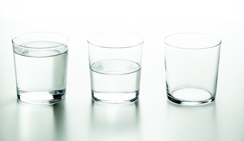 Three glasses of water on a white surface.