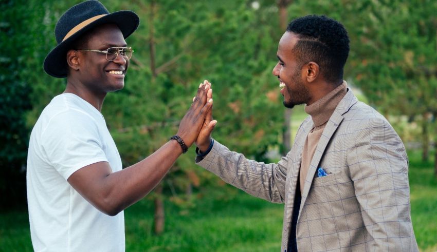 Two men giving each other high fives in the park.