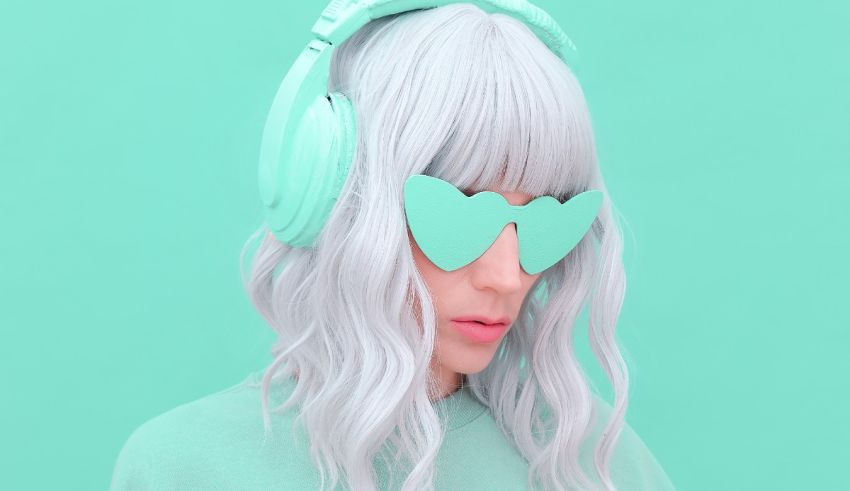 A woman wearing headphones on a green background.