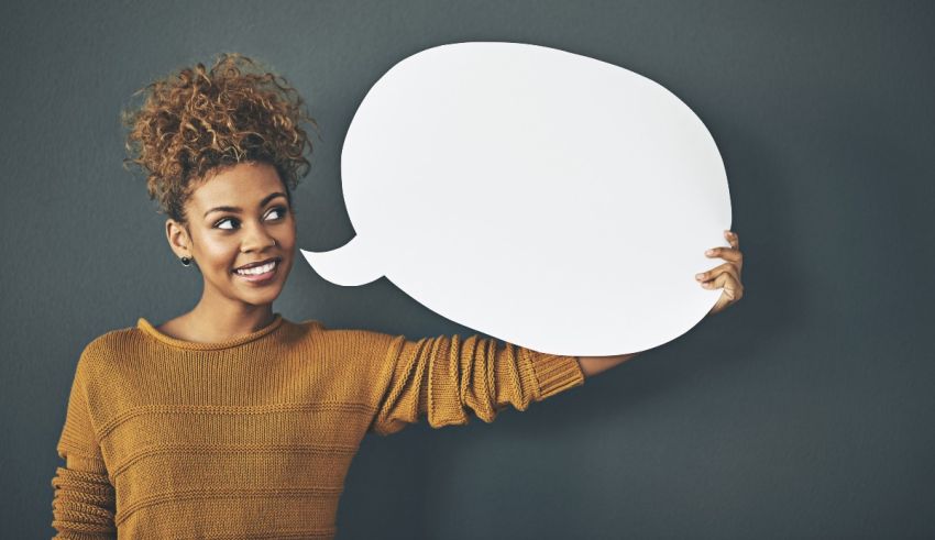 A young woman holding up a speech bubble.