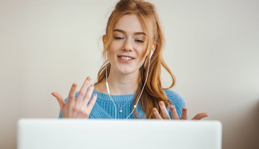 A young woman is sitting in front of a laptop.