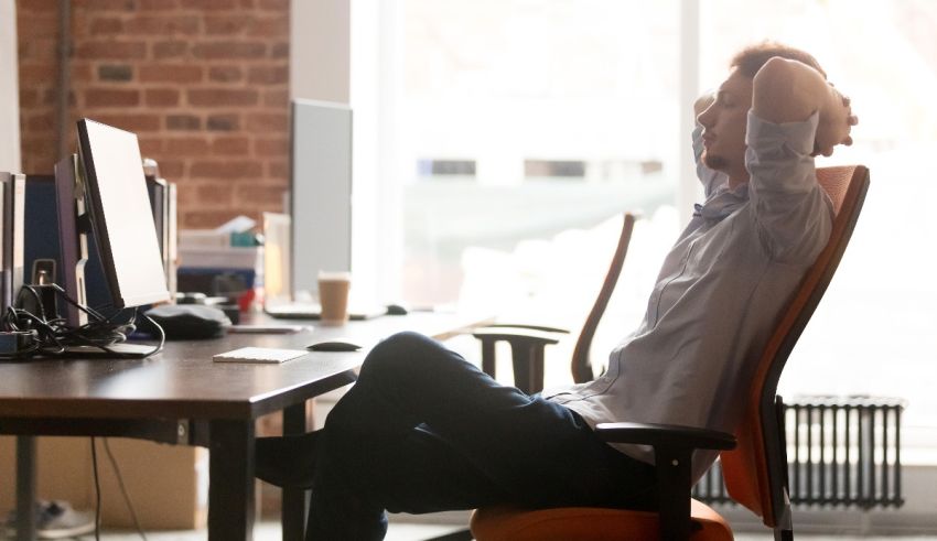 A man relaxes in his office chair.