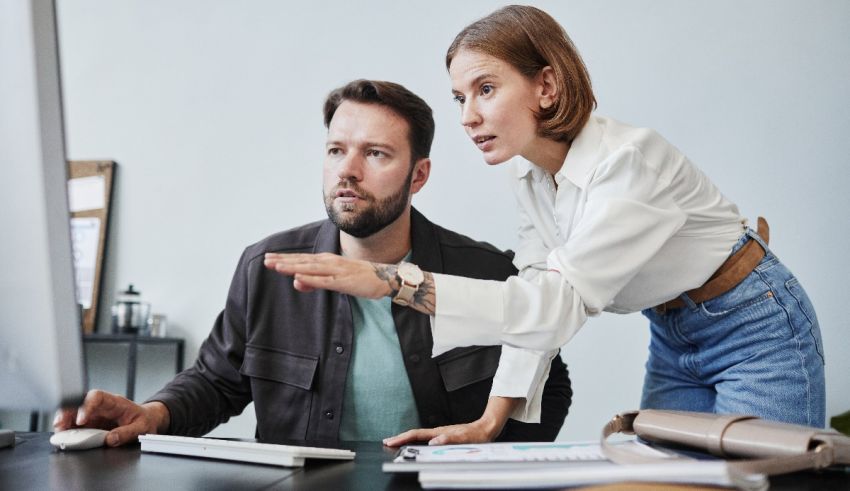 A man and woman are looking at a computer screen.