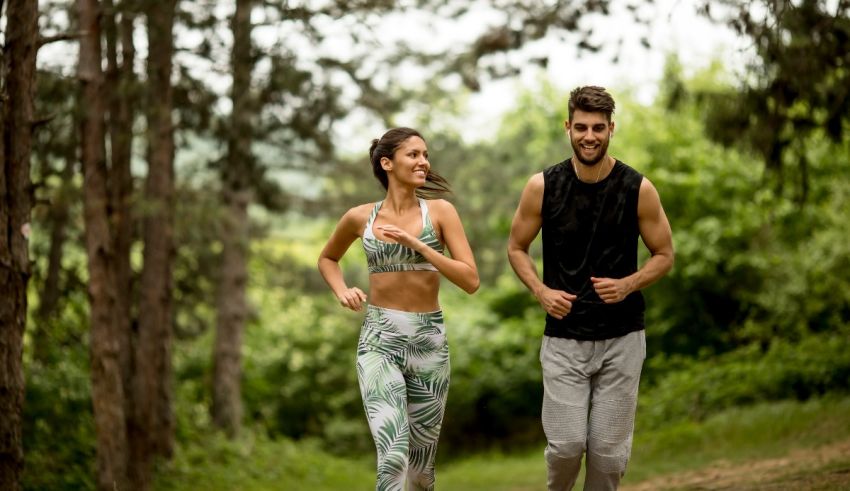 A man and woman jogging in the woods.