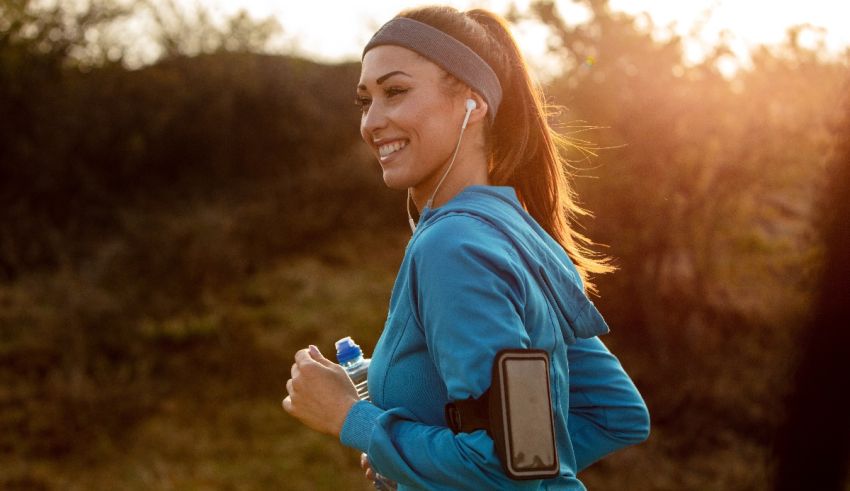 A woman jogging in a field with headphones on.