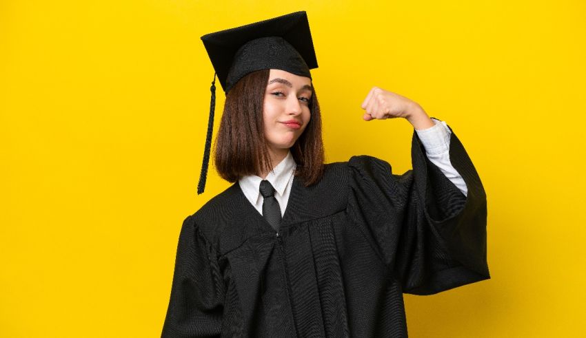 A young woman in a graduation gown flexing her biceps on a yellow background.