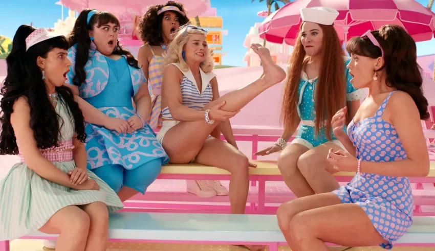 A group of women sitting on a pink bench.