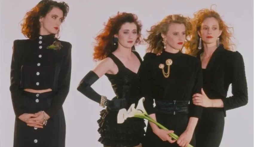 Four women in black outfits posing for a picture.