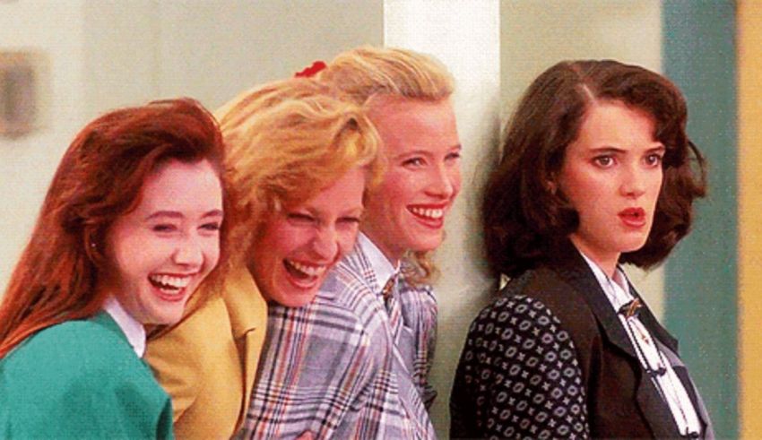 A group of women are laughing together in a hallway.