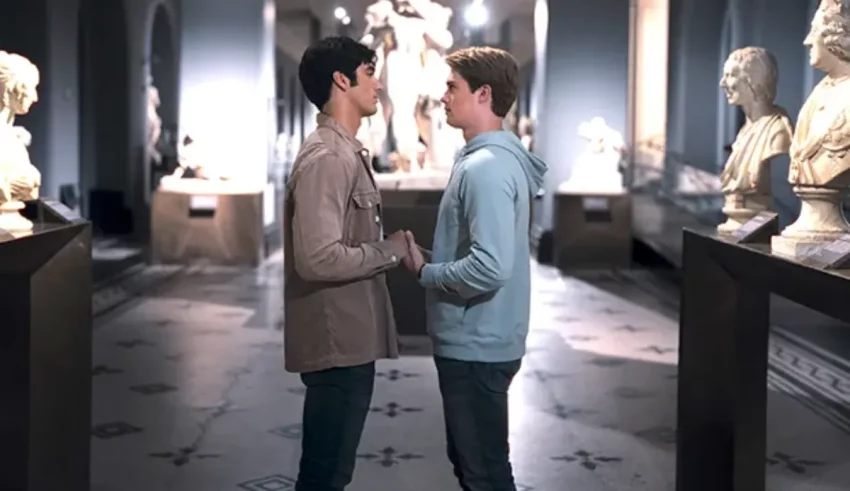 Two young men in a museum talking to each other.