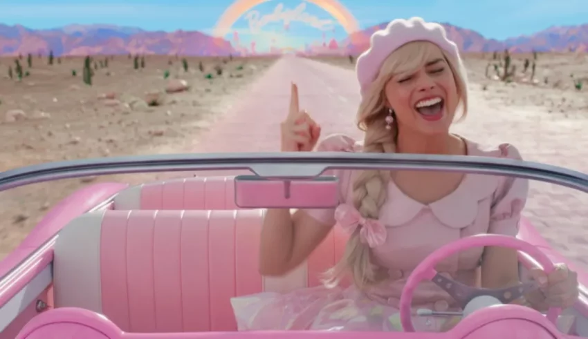 A girl driving a pink car with a rainbow in the background.