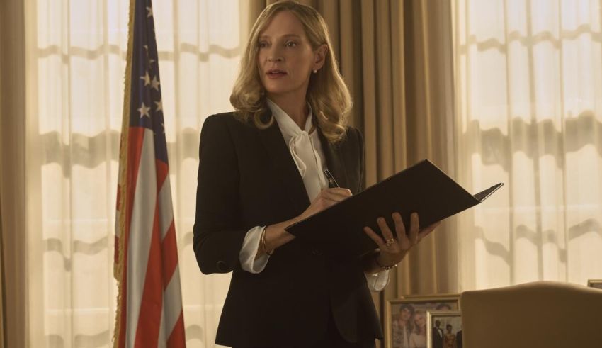 A woman in a suit standing in front of an american flag.