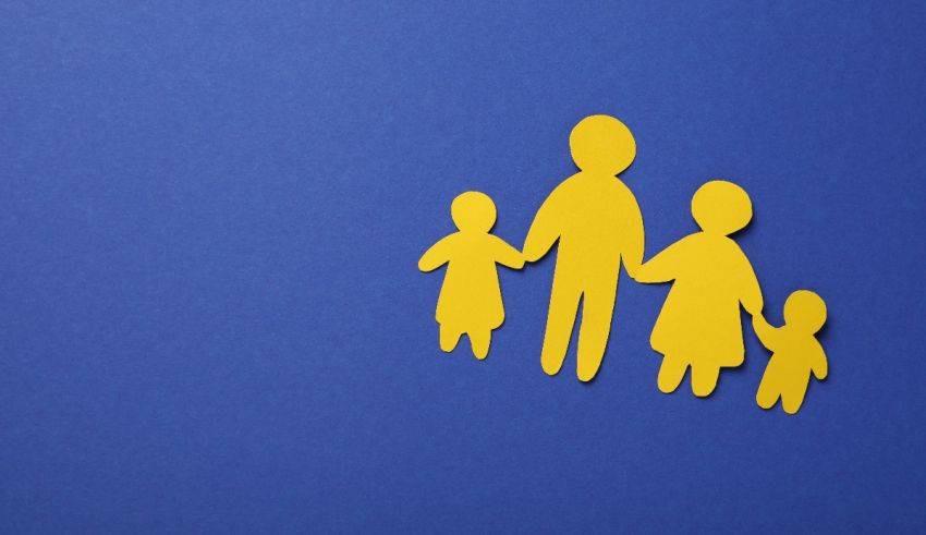 A yellow paper cut out of a family on a blue background.
