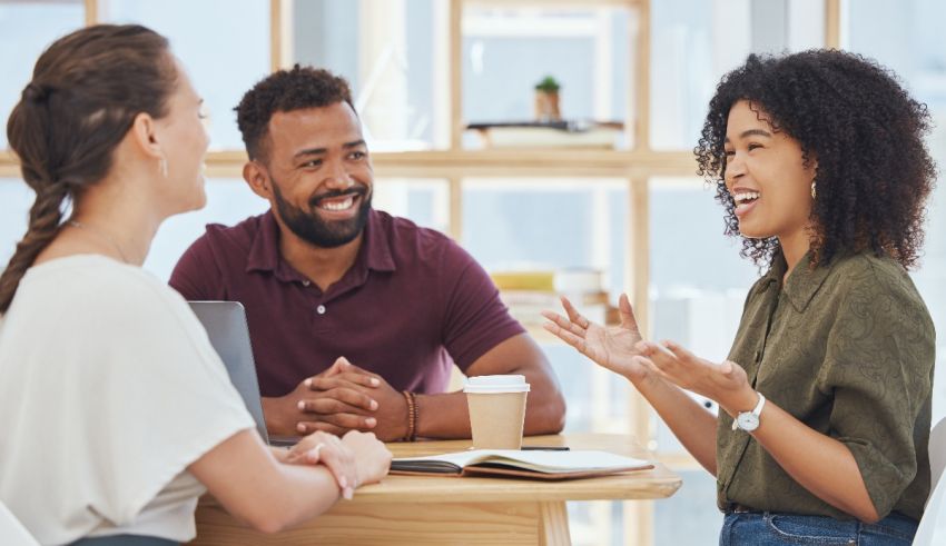 A group of people talking at a table in an office.