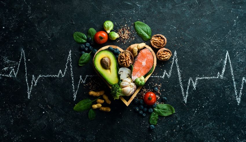 A heart shaped heart with fruits and vegetables on a black background.