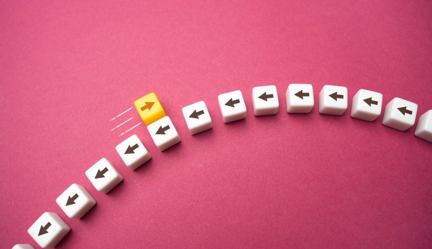 A row of white cubes with a yellow arrow in the middle.