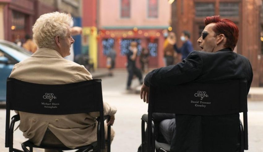 Two people sitting in chairs on a street.