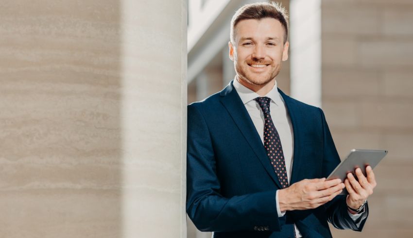 A smiling businessman holding a tablet computer.