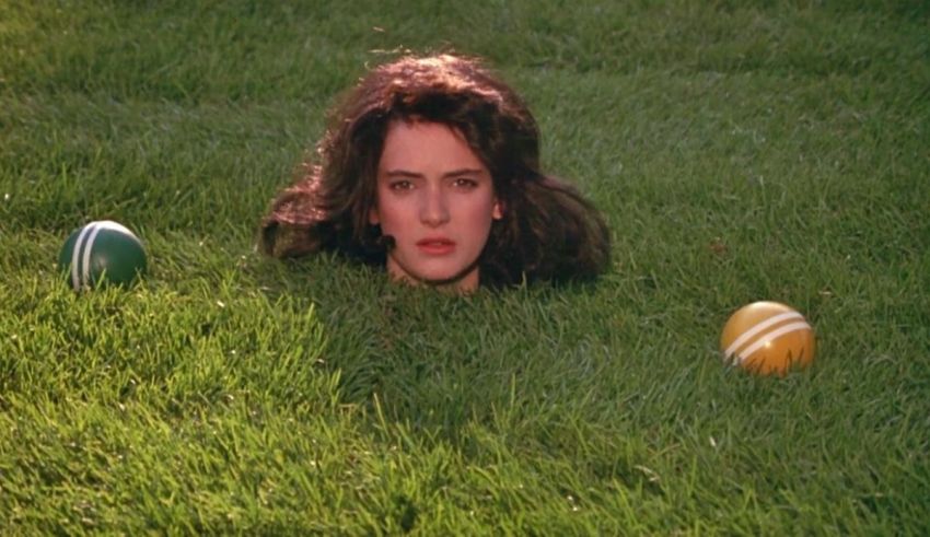 A woman laying in the grass with two balls.