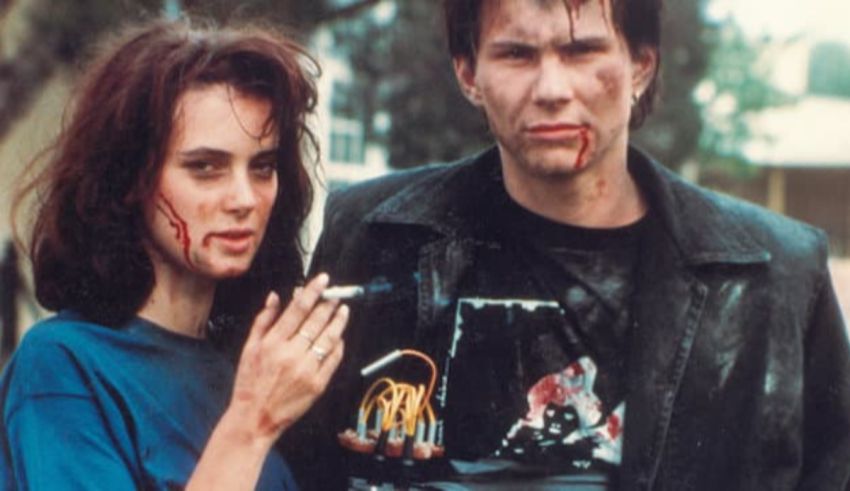 A man and woman with blood on their faces standing next to each other.