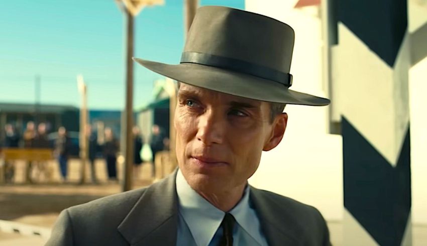 A man in a suit and hat is standing outside.