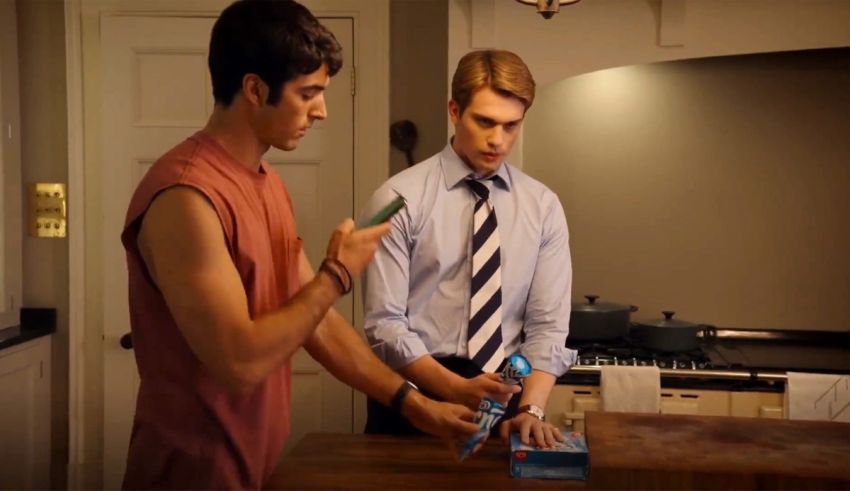 Two men standing next to each other in a kitchen.