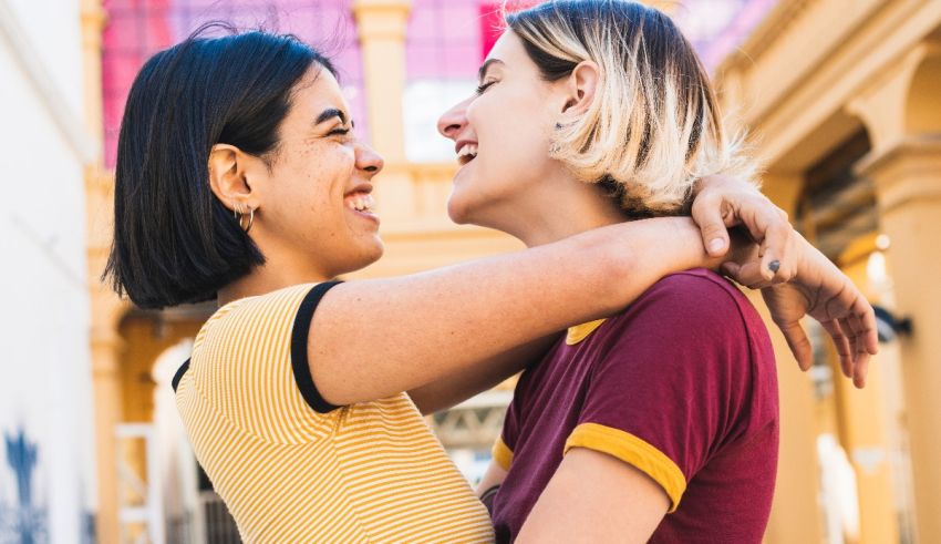 Two women hugging each other in front of a building.