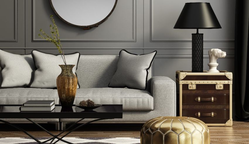 A living room with a grey couch and gold accents.